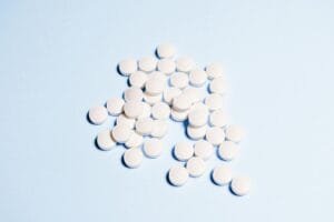 white round medication pills on sky blue surface